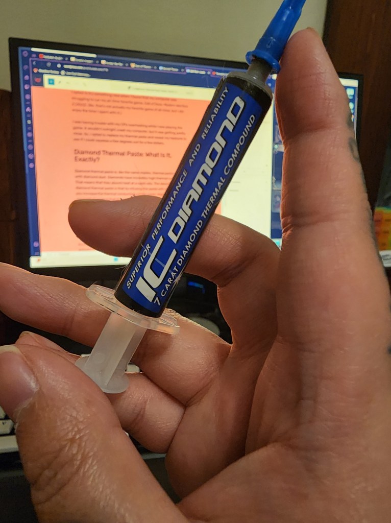 An image of a hand holding a tube of Innovation Cooling Diamond Thermal Paste