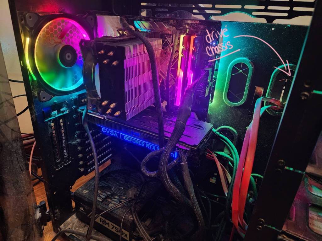 An image of the inside of a custom built PC with rainbow LEDs with the drive chassis visually highlighted.