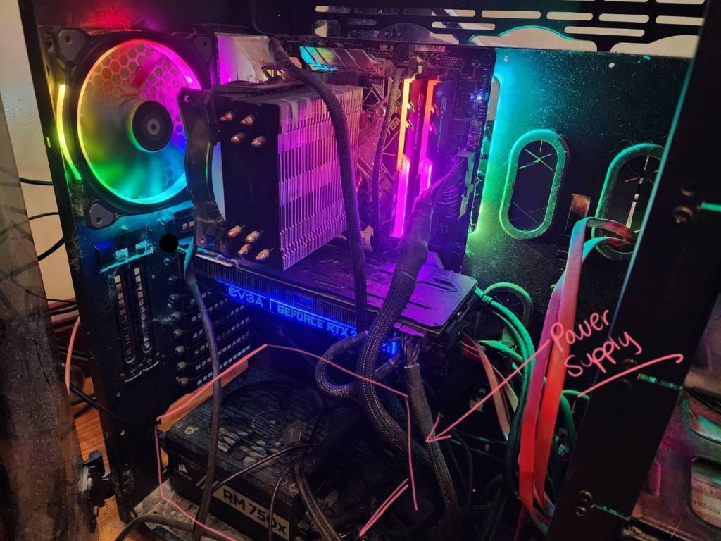 An image of the inside of a custom built PC with rainbow LEDs with the PSU visually highlighted.