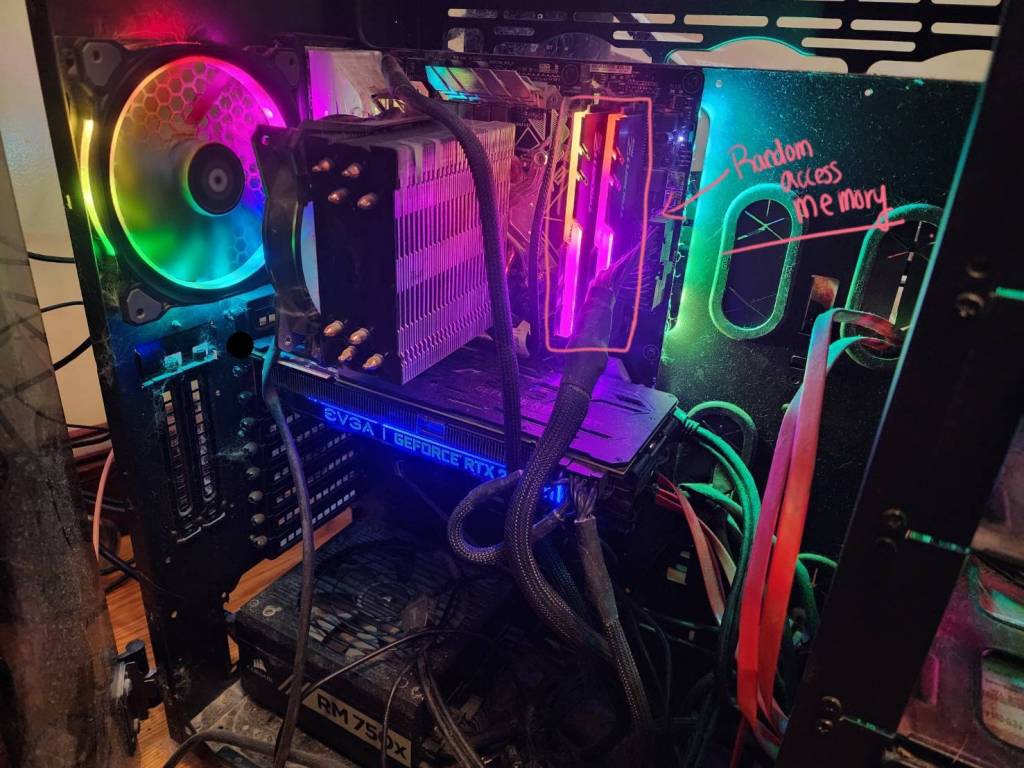 An image of the inside of a custom built PC with rainbow LEDs with the RAM visually highlighted.